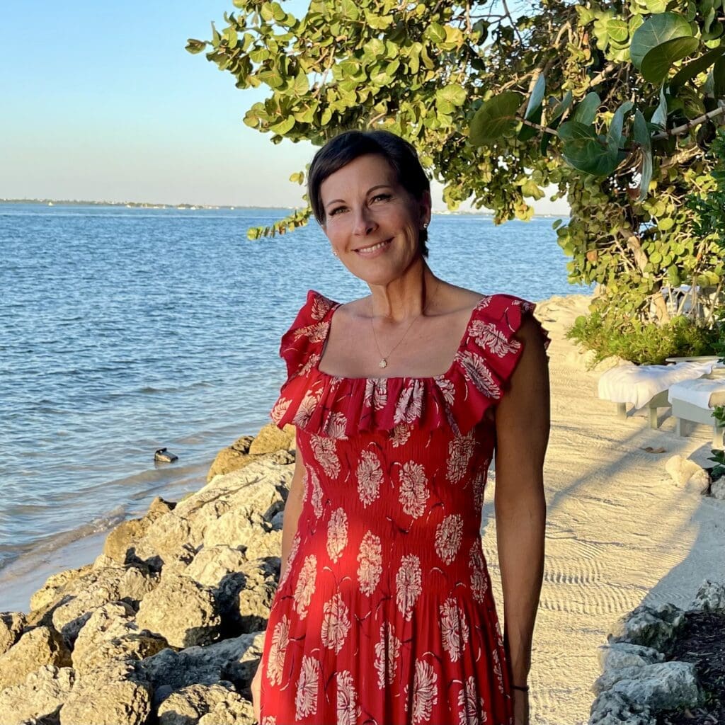 Woman in red dress by the sea.